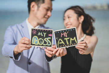WeddLin 新娘穿著輕盈黑婚紗在海邊自助旅拍，與新郎拿著趣味字卡自然互動，展現輕婚紗方便移動的優勢